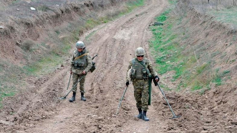 جنديان أذريان يبحثان عن ألغام في منطقة حدودية مجاورة لأرمينيا