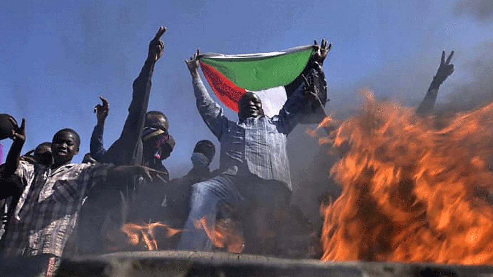 رجل يرفع علم السودان احتجاجا على الانقلاب العسكري في الخرطوم يوم السبت 13 تشرين الثاني/ نوفمبر 2021