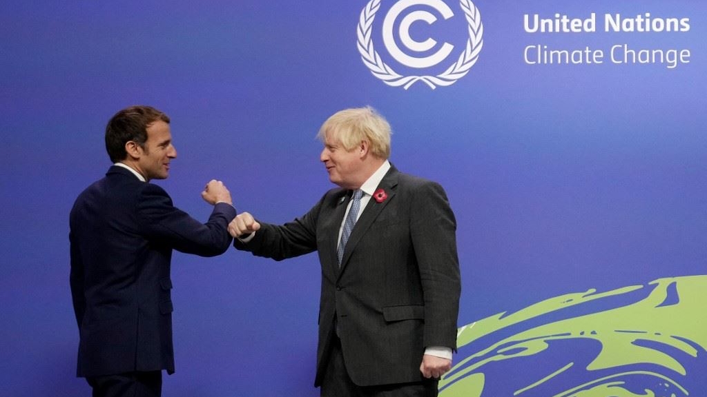 رئيس الوزراء البريطاني بوريس جونسون والرئيس الفرنسي إيمانويل ماكرون يتبادلان التحية عند وصولهما إلى قمة المناخ في غلاسكو
