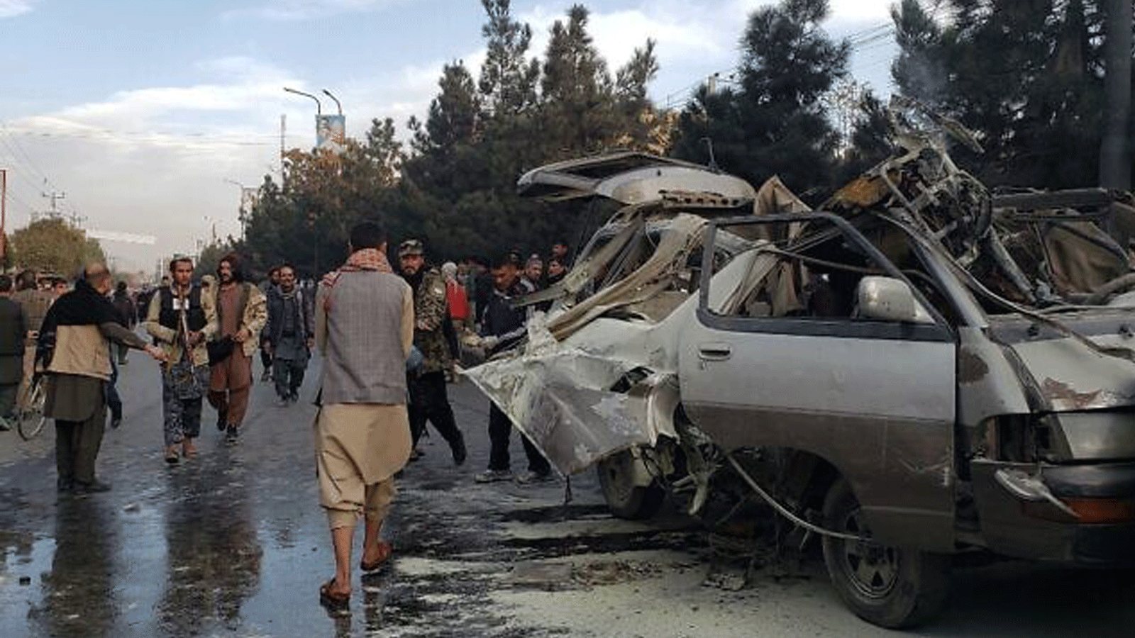 سكان يتجمعون بجوار حافلة صغيرة مدمرة بعد انفجار قنبلة أسفر عن مقتل شخصين وإصابة خمسة بجروح في كابول. في 17 تشرين الثاني/ نوفمبر 2021