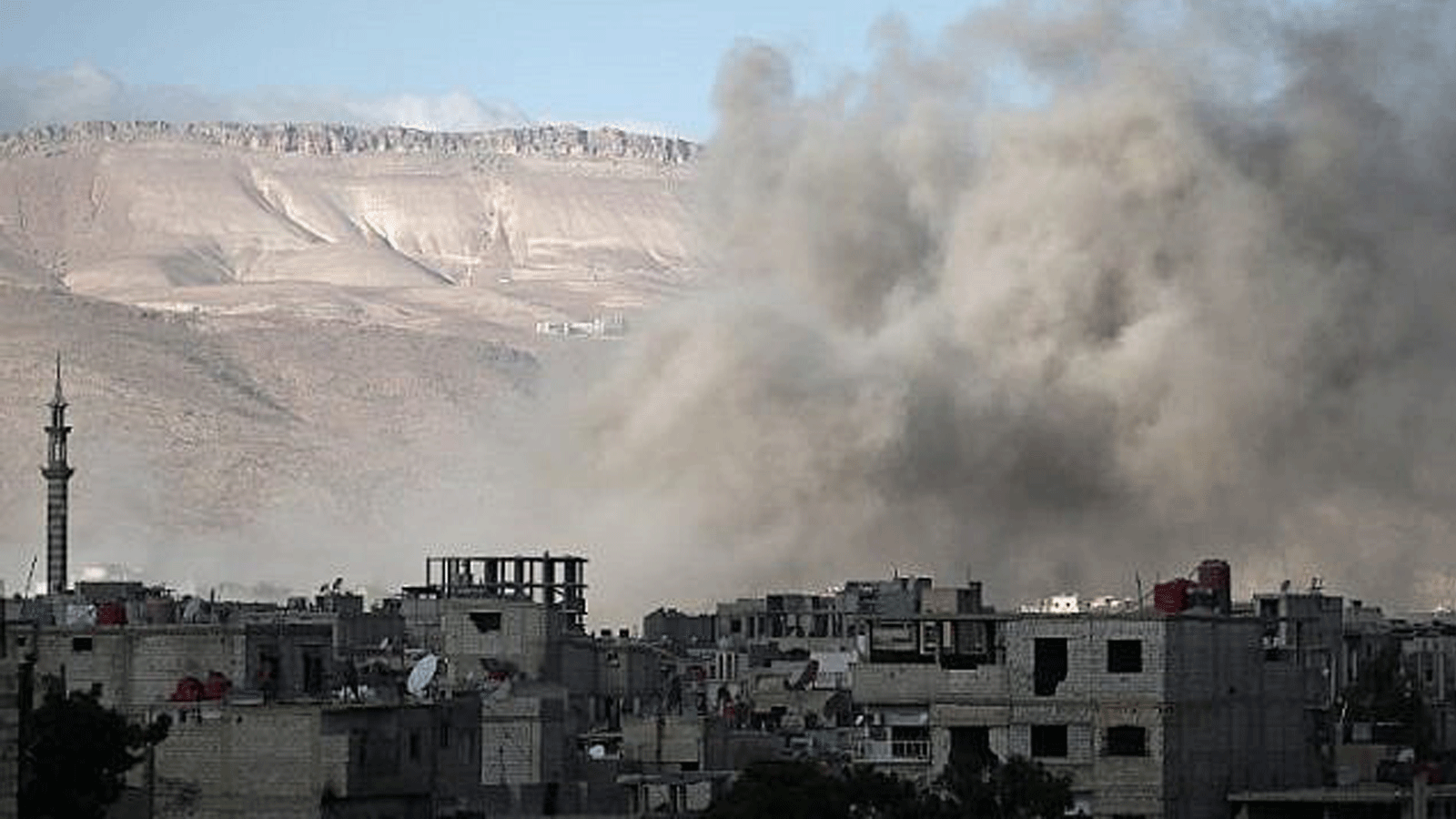 دخان يتصاعد من المباني إثر غارة جوية في عربين بمنطقة الغوطة الشرقية بضواحي العاصمة السورية دمشق في 2 كانون الثاني/ يناير 2018.