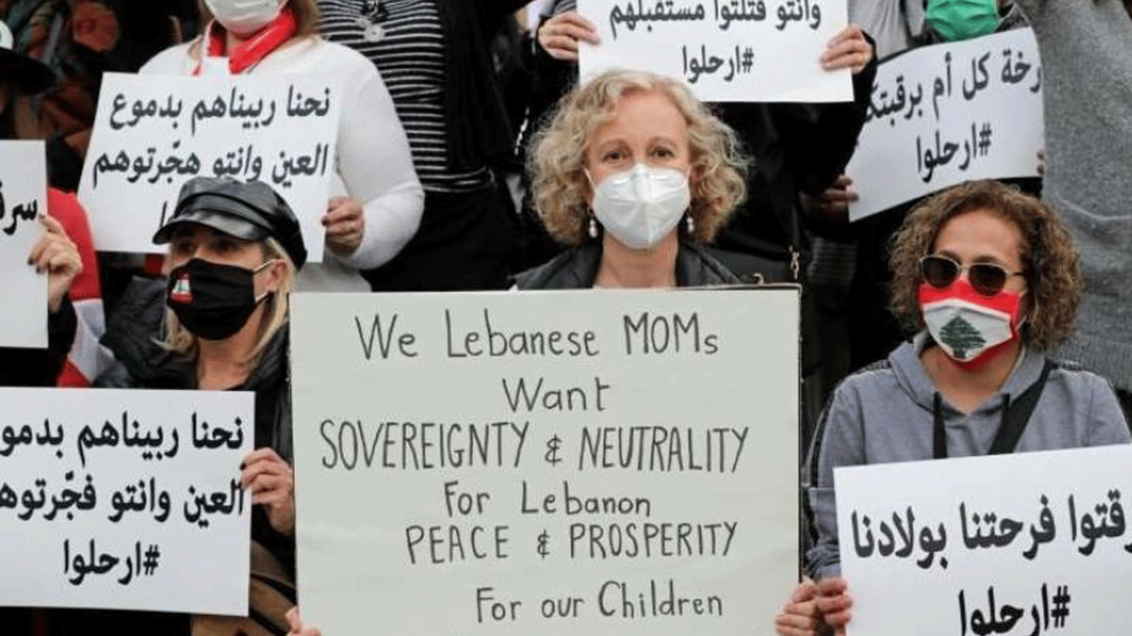 نساء لبنانيات يحملن لافتات أثناء احتجاجهن على الشلل السياسي الذي تعاني منه البلاد والأزمة الاقتصادية العميقة في بيروت عشية عيد الأم في البلاد.