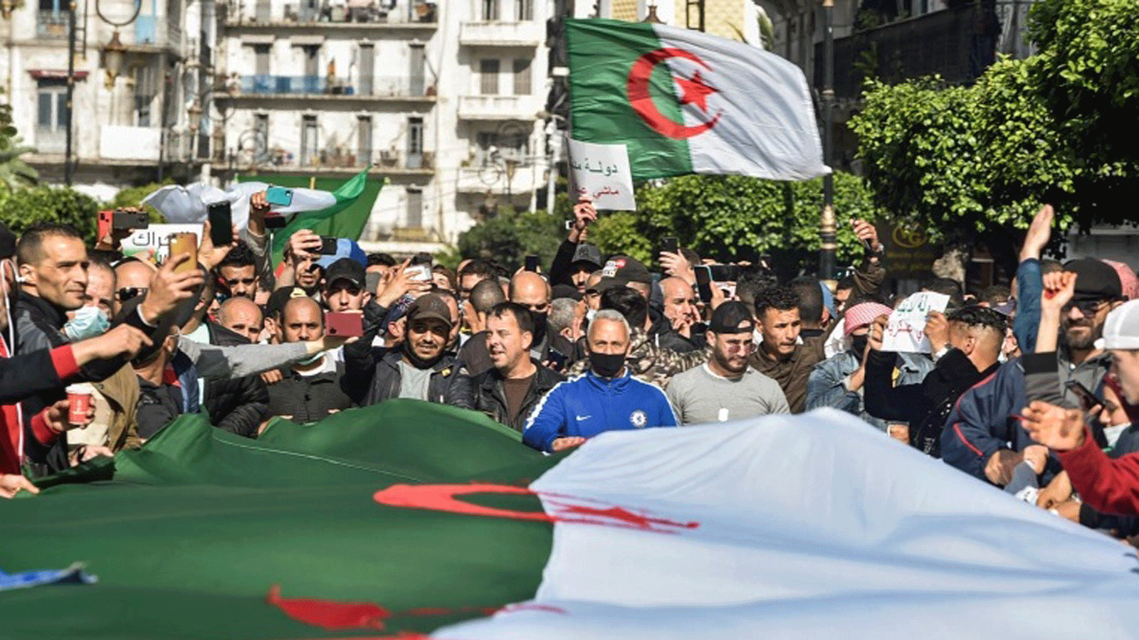 جزائريون يلوحون بالأعلام الوطنية خلال مظاهرة مناهضة للحكومة في العاصمة الجزائر يوم 5 آذار/ مارس 2021