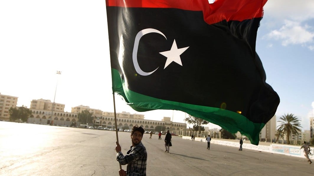 صورة من الأرشيف لليبي يحمل علم بلاده