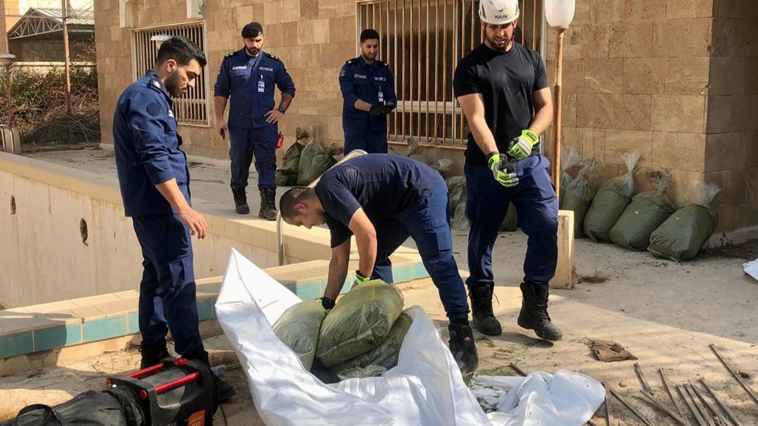 رجال الإطفاء الكويتيون ينقلون المواد المشبوهة