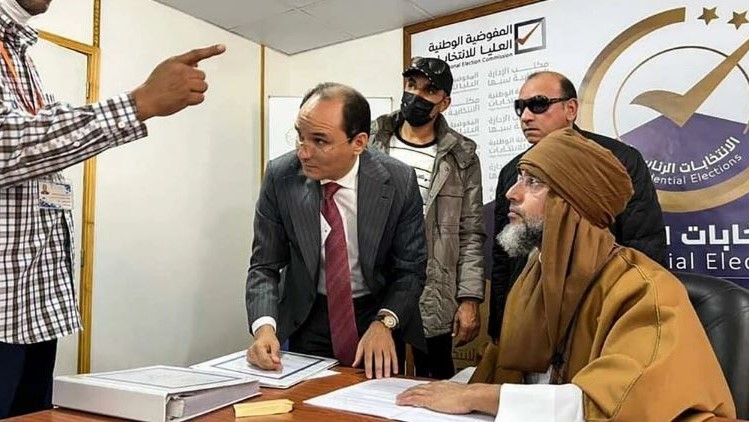 صورة وزعتها المفوضية العليا للانتخابات في ليبيا في 14 تشرين الثاني/نوفمبر 2021 تظهر سيف الإسلام القذافي وهو يقدم أوراق ترشحه الى الانتخابات الرئاسية في سبها في جنوب البلاد