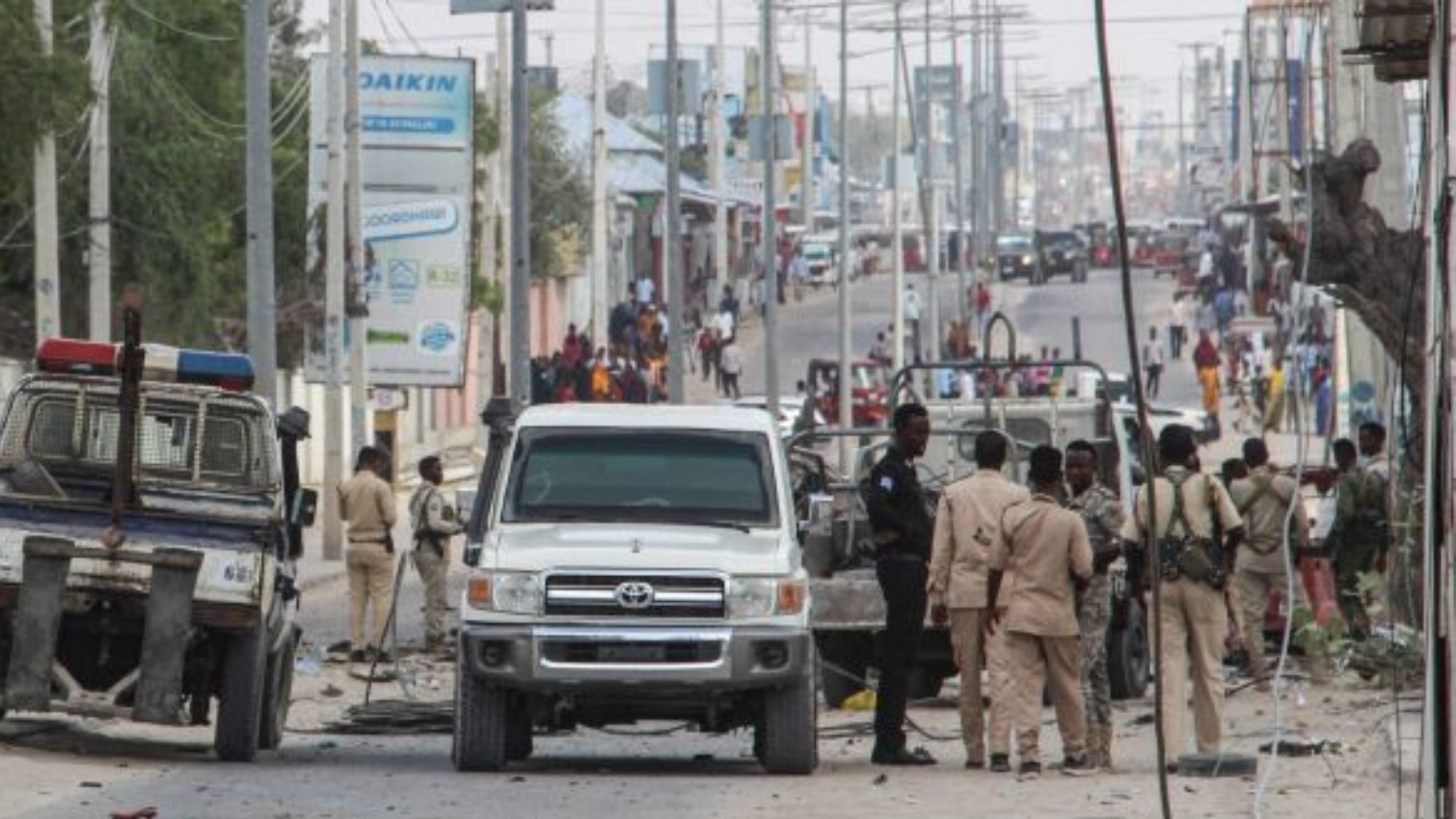 ضباط وأفراد من الشرطة يقفون في موقع انفجار القنبلة في مقديشو، الصومال. في 25 تشرين الثاني/نوفمبر 2021.