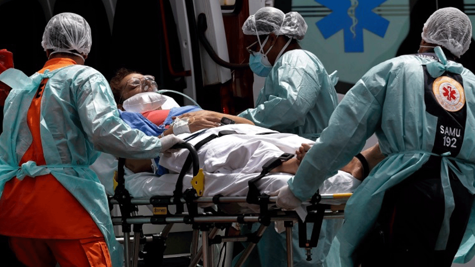 عمال الرعاية الصحية يأخذون مريضًا يشتبه في إصابته بـ COVID-19 من سيارة إسعاف في برازيليا/ البرازيل