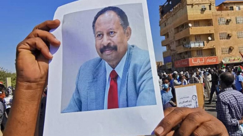 متظاهر سوداني يحمل صورة لعبد الله حمدوك خلال احتجاجات في الخرطوم في 13 نوفمبر 2021