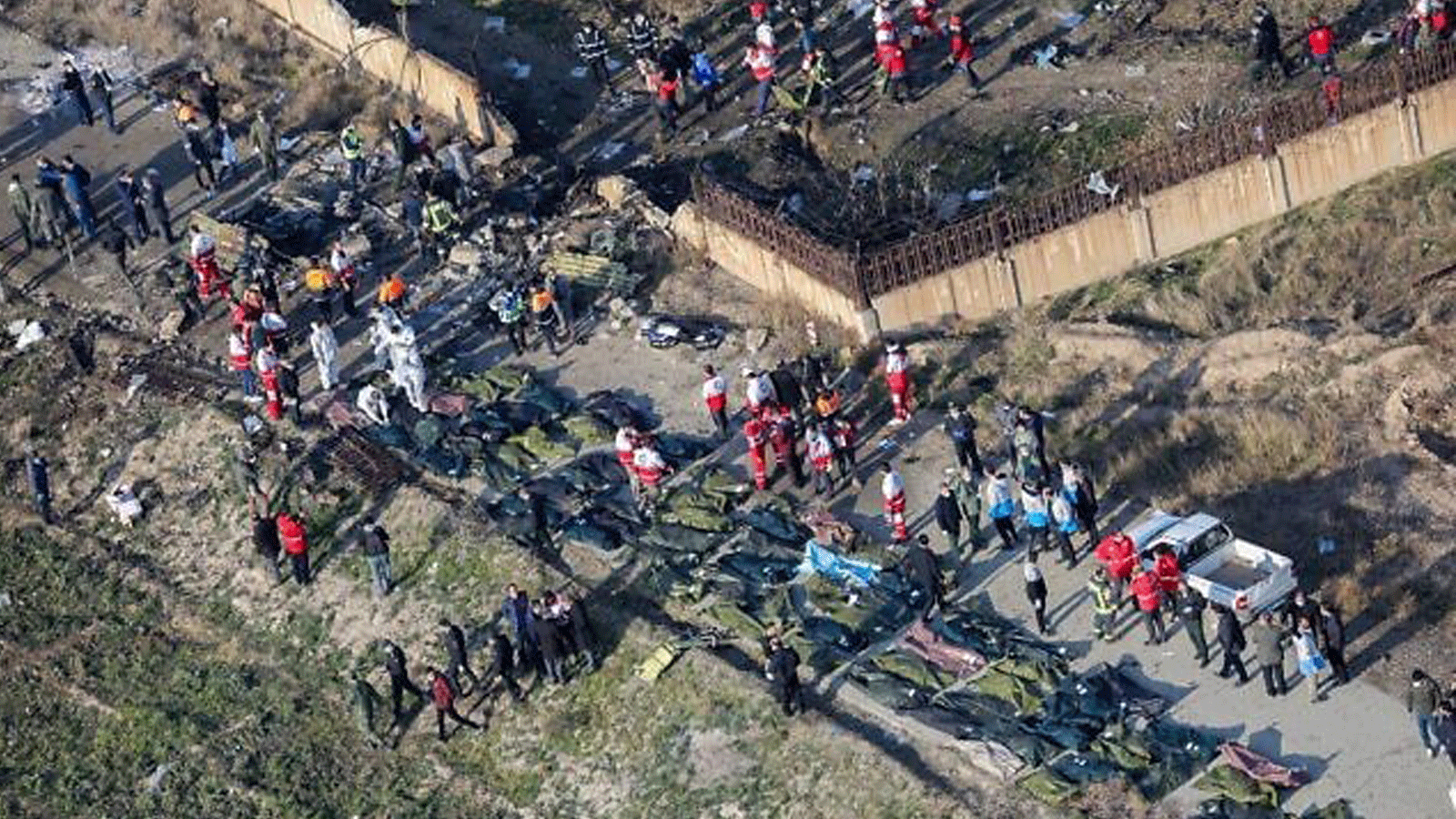 أشخاص وفرق إنقاذ وسط الجثث والحطام بعد أن أسقطت القوات الإيرانية بطريق الخطأ طائرة أوكرانية تقل 176 راكبا بالقرب من مطار الإمام الخميني في العاصمة الإيرانية طهران في 8 كانون الثاني/ يناير 2020