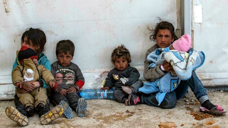أطفال يجلسون على الأرض في مخيّم الهول في سوريا في 18 مارس 2021