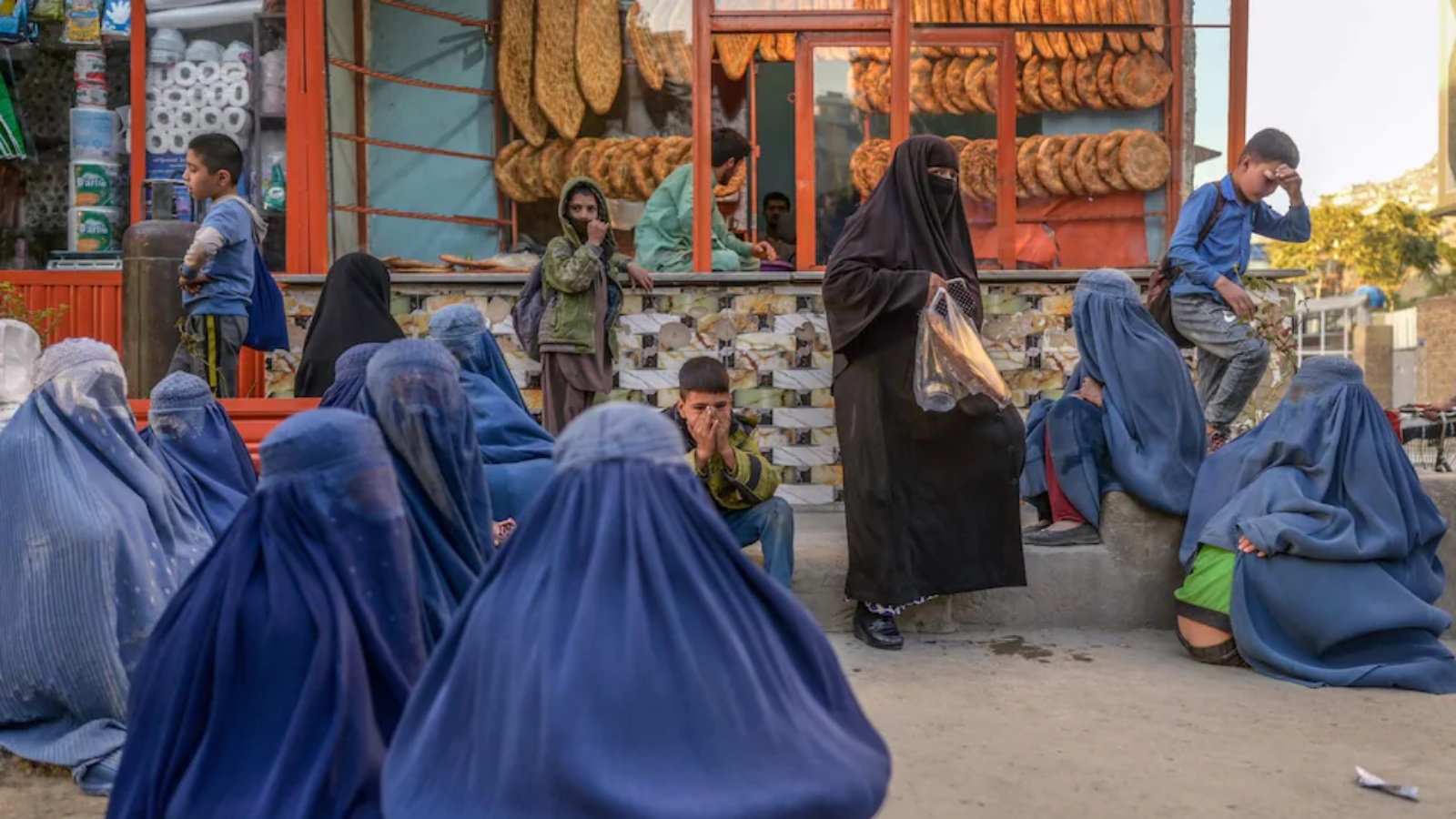 نساء ينتظرن تبرعات الخبز خارج مخبز في كابول (أرشيفية)