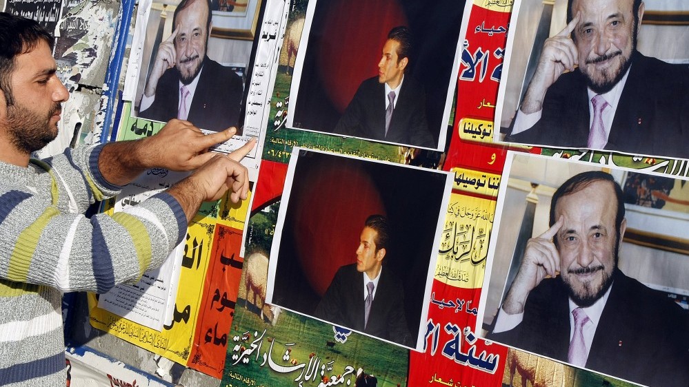 شاب علوي يلصق صور رفعت الأسد على جدار في مدينة طرابلس شمال لبنان في 6 ديسمبر 2007