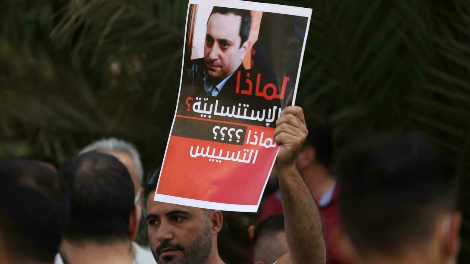 لافتة تحمل صورة القاضي طارق بيطار المحقق العدلي في انفجار مرفأ بيروت، يرفعها متظاهر معارض للقاضي في العاصمة اللبنانية بتاريخ 14 تشرين الأول/أكتوبر 2021