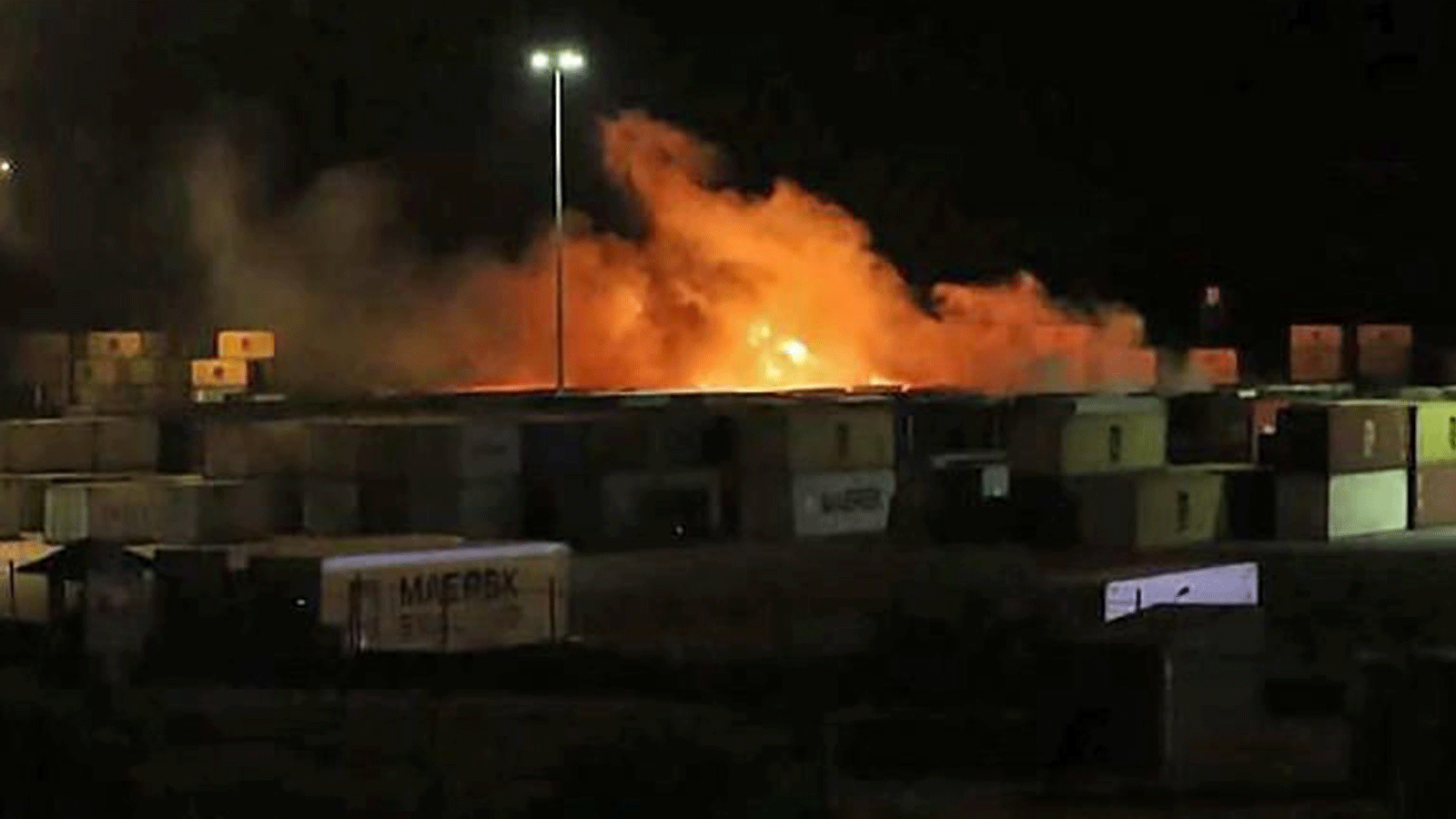صورة مأخوذة من شريط فيديو نشرته وكالة الأنباء السورية الرسمية (سانا) في 7 كانون الأول/ديسمبر 2021 تُظهر حريقًا بالقرب من حاويات في ميناء اللاذقية السوري.