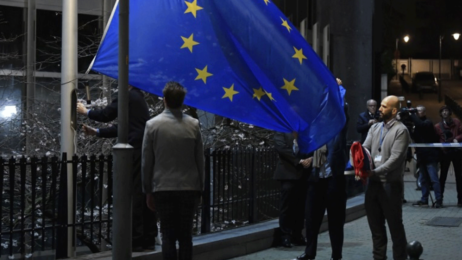 موظف يحمل علم المملكة المتحدة مطويًا بعد إزالته من مبنى البرلمان الأوروبي في بروكسل في يوم خروج بريطانيا من الاتحاد الأوروبي. 31 كانون الثاني/يناير 2020