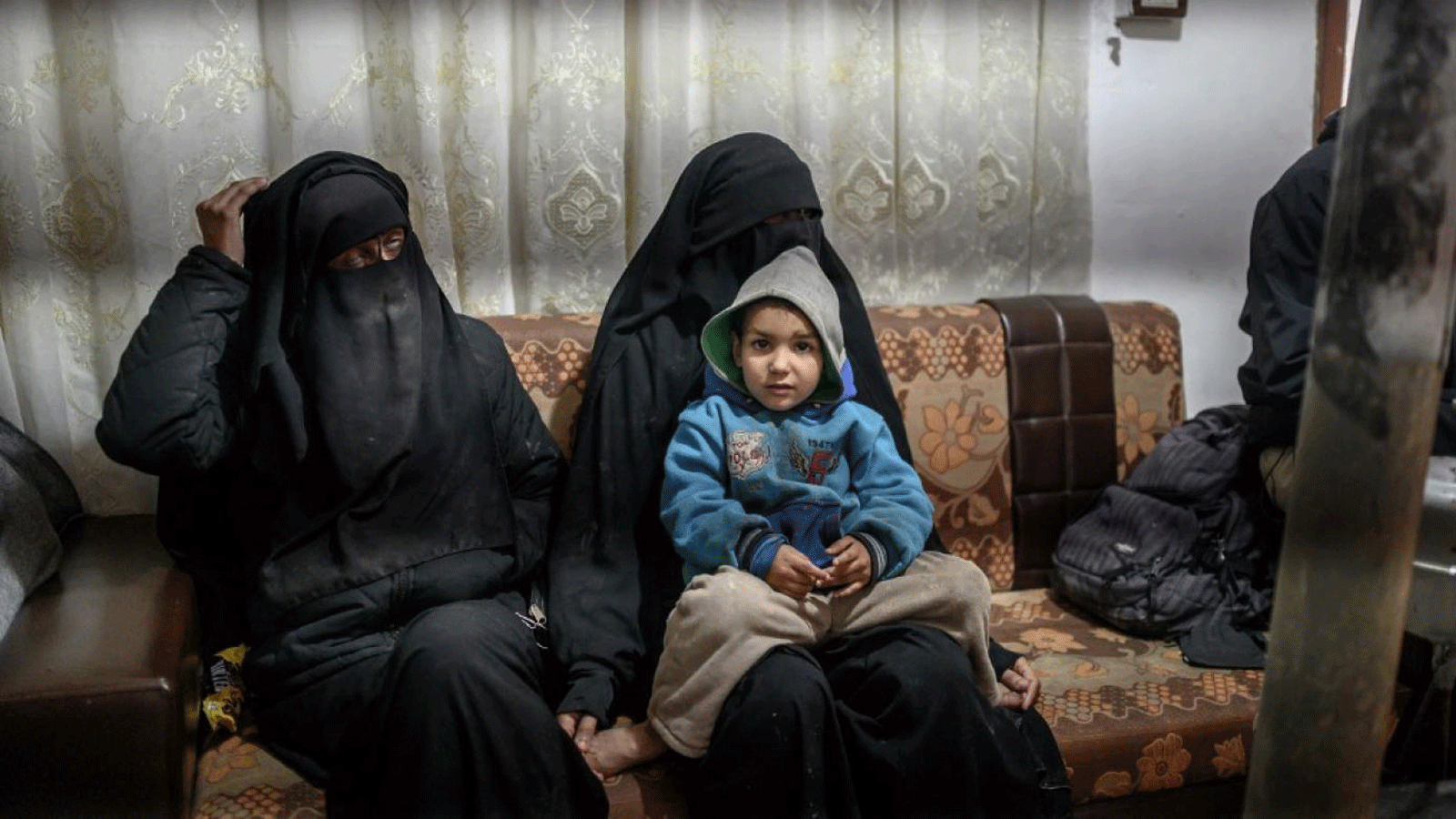  امرأتان فرنسيتان محتجزتان فرتا من تنظيم الدولة الإسلامية تجلسان مع أطفالهما أثناء حديثهما لمراسل وكالة فرانس برس في مخيم الهول في 17 شباط/ فبراير 2019.