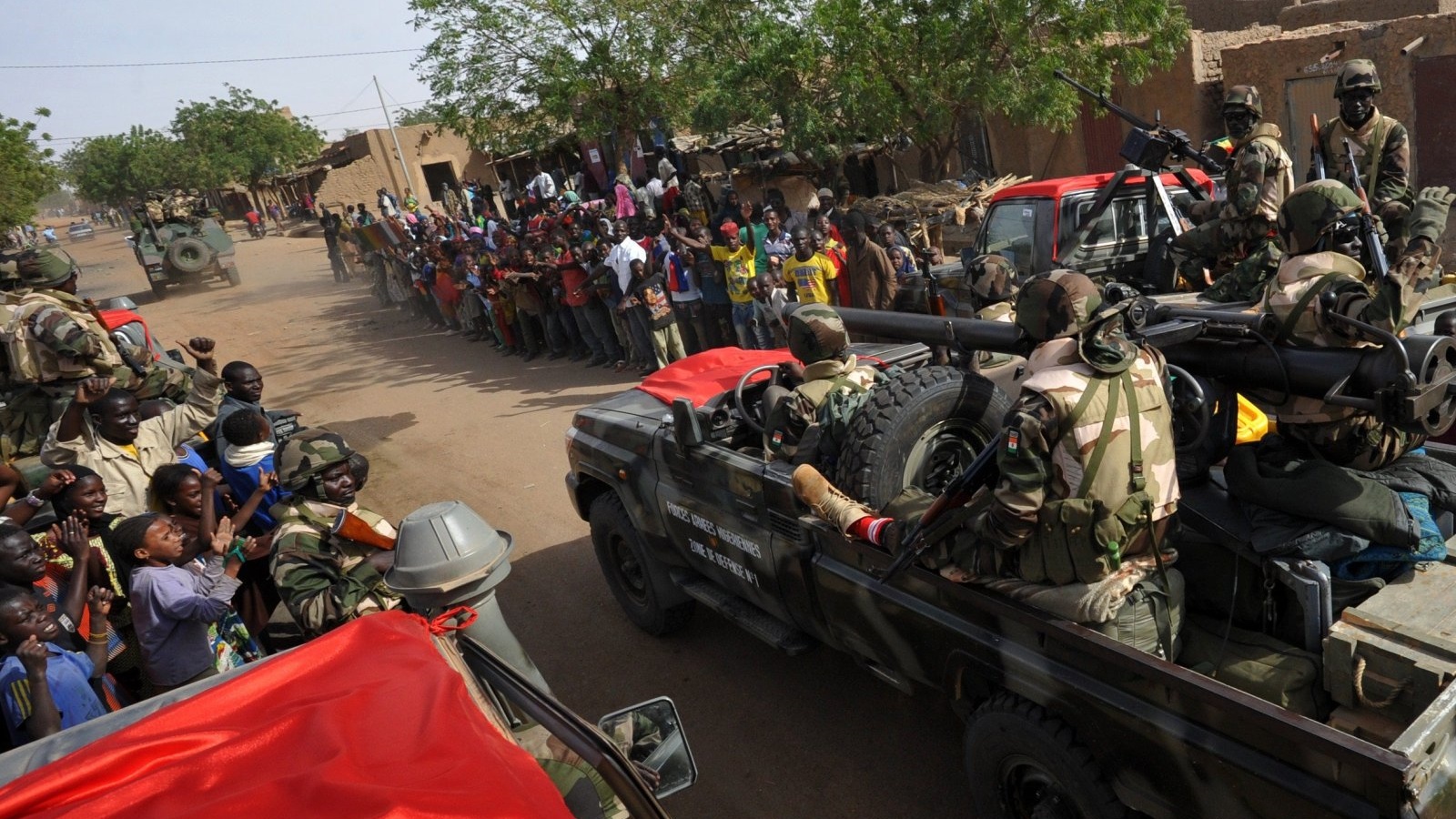 الناس يهتفون على جانب الطريق في بلدة أنسونغو الواقعة جنوب مدينة جاو شمال مالي، مع دخول قوات النيجر المدينة.