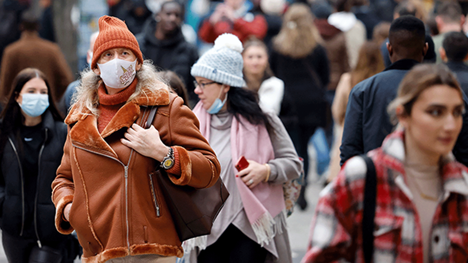 مواطنون يسيرون بقناع الوجه في بريطانيا حيث تخطت إصابات كورونا الـ 15 ألفا في المستشفيات