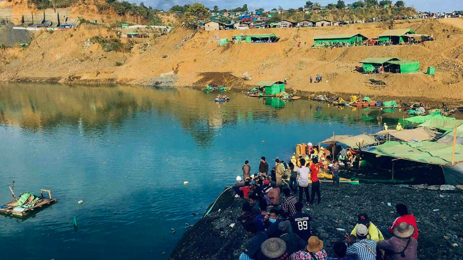 أشخاص يتابعون مجريات عمليات البحث عن ضحايا انزلاق للتربة في منجم لليشم في شمال بورما في 22 كانون الأول/ديسمبر 