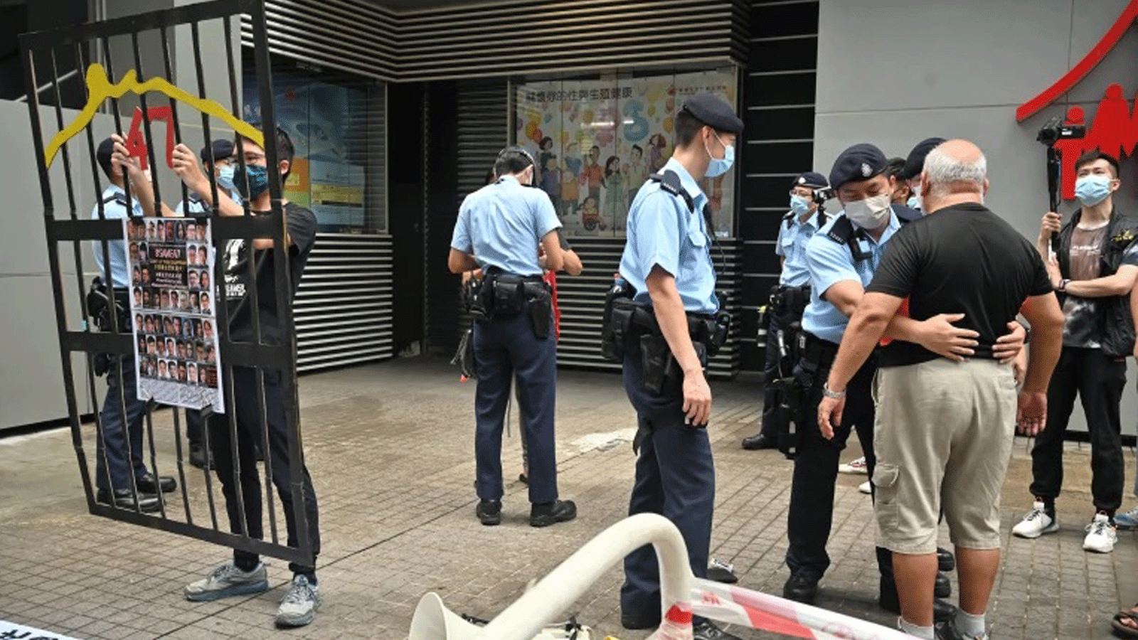 الشرطة تقوم بتفتيش متظاهر بينما بدأت مجموعة صغيرة من سكان هونغ كونغ في اختيار لجنة الانتخابات