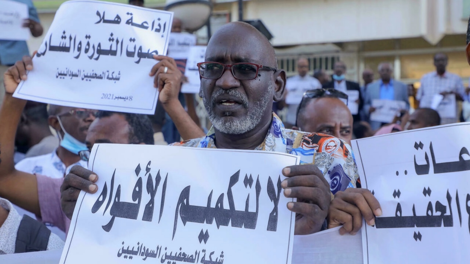 صحافيون سودانيون يرفعون لافتات خلال تظاهرة أمام مقر إذاعة 