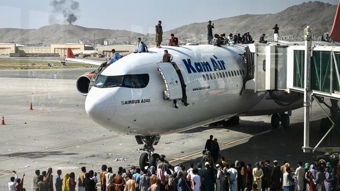 أفغان في مطار كابل يغادرون على متن طائرة جاثمة هناك في أثناء الانسحاب الأميركي من أفغانستان في أغسطس الماضي