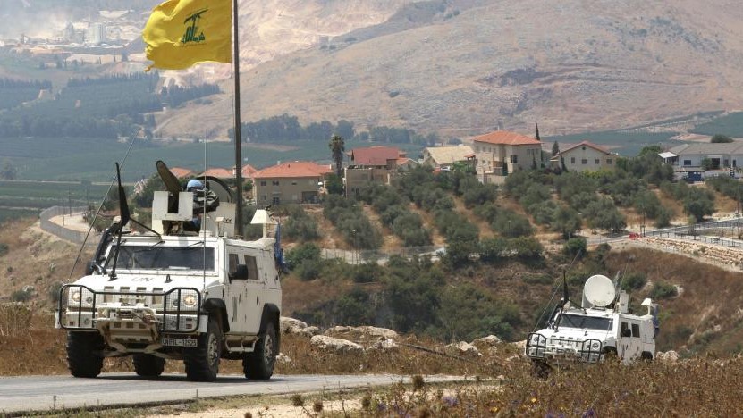 دورية لقوات الطوارئ الدولية على الخط الفاصل بين لبنان وإسرائيل، ويظهر علم حزب الله في الجانب اللبناني