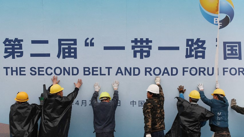 صورة أرشيفية لعمال صينيين يعلقون لوحة إعلانية عن أحد الأنشطة المرتبطة بمبادرة الحزام والطريق