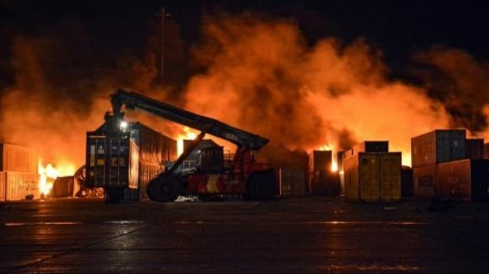 صورة وزعتها وكالة الأنباء السورية سانا لعناصر الإطفاء أثناء محاولتهم إخماد الحريق في ميناء اللاذقية السوري بتاريخ 28 كانون الأول/ديسمبر 2021