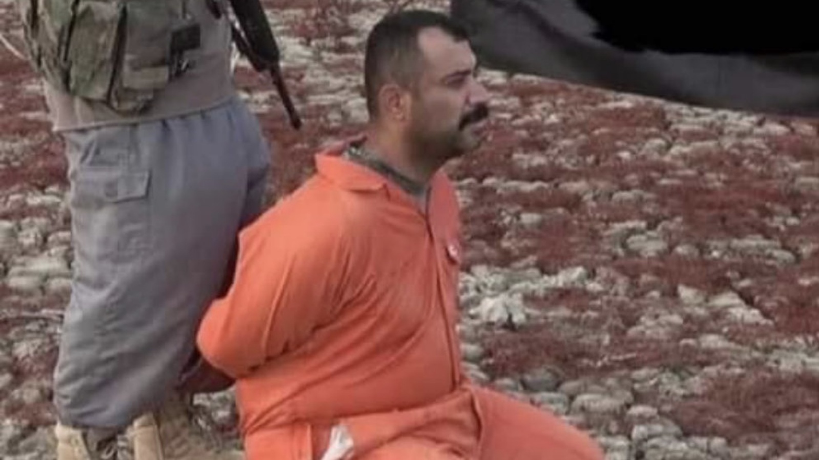 العقيد في الجيش العراقي ياسر الجوراني وخلفه أحد عناصر داعش يبدو أنها التقطت قبيل عملية نحره كما قال التنظيم الأربعاء 29 كانون الأول/ ديسمبر 2021 (تويتر)