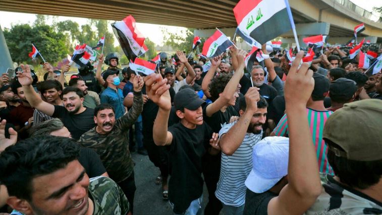 متظاهرون عراقيون يرفعون الأعلام الوطنية خلال تظاهرة احتجاج على نتيجة انتخابات الشهر الماضي بالقرب من مدخل المنطقة الخضراء في بغداد في 5 نوفمبر 2021