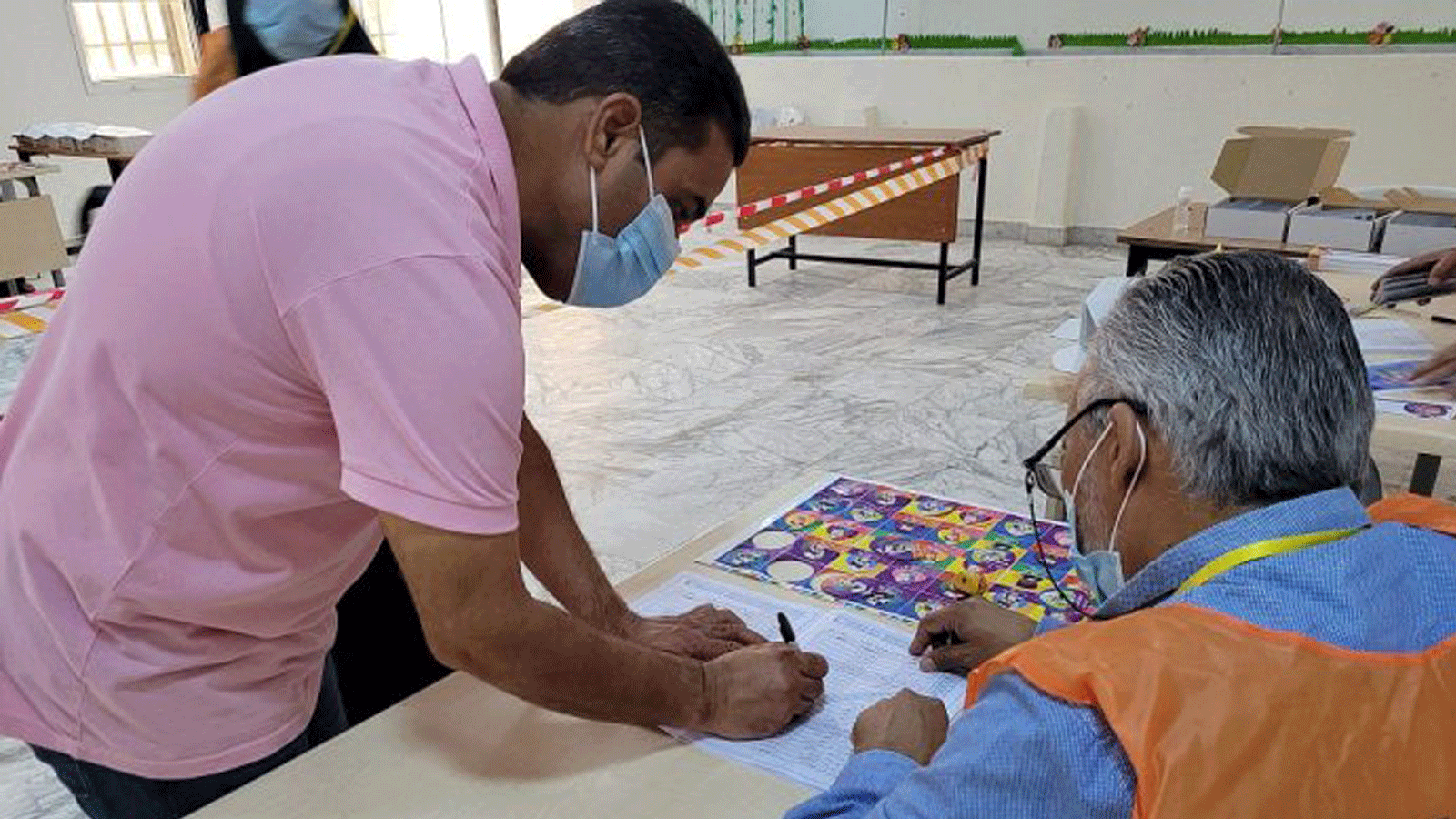 رجلٌ ليبي يسجل للتصويت داخل مركز اقتراع في طرابلس، في 8 تشرين الأول/ نوفمبر 2021. 