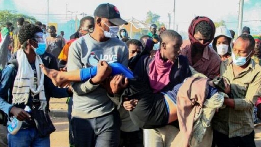  سودانيون يحملون امراة مصابة خلال تظاهرة في الخرطوم ضد الحكم العسكري في الثاني من يناير 2022