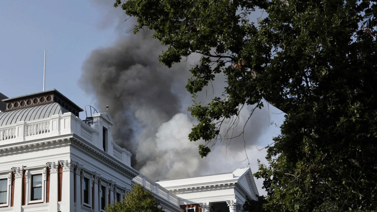 دخان يتصاعد من سطح مبنى في منطقة برلمان جنوب أفريقيا في كيب تاون في 2 كانون الثاني/يناير 2022، أثناء الحريق.