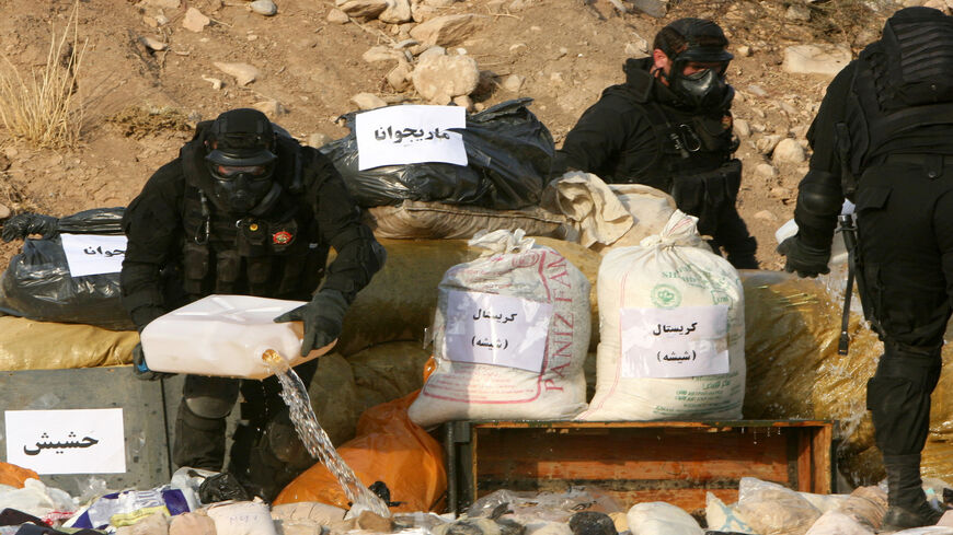 صورة من الأرشيف لقوات الشرطة في أربيل بكردستان العراق تصب الوقود على كمية مصادرة من المخدرات المنوعة تمهيداً لإحراقها