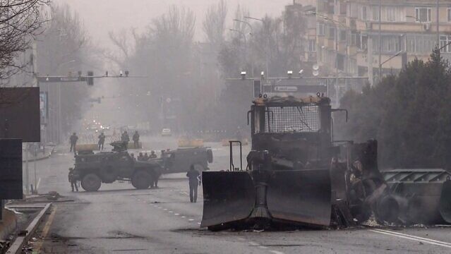 الجنود ومركباتهم العسكرية يغلقون شارعًا في وسط ألماتي في 7 يناير 2022 ، بعد أعمال عنف اندلعت في أعقاب احتجاجات على ارتفاع أسعار الوقود
