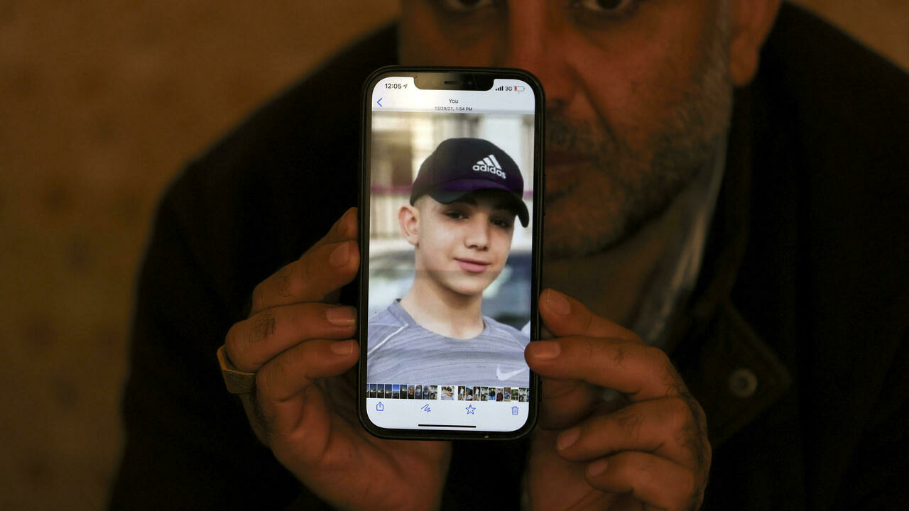 لصحافي الفلسطيني معمر نخلة يعرض صورة لابنه أمل (17 عاما) والمحتجز ضمن إجراء الاعتقال الإداري في السجون الإسرائيليةفي مخيم الجلزون للاجئين الفلسطينيين في الضفة الغربية المحتلة في الثامن من كانون الثاني/يناير 2022