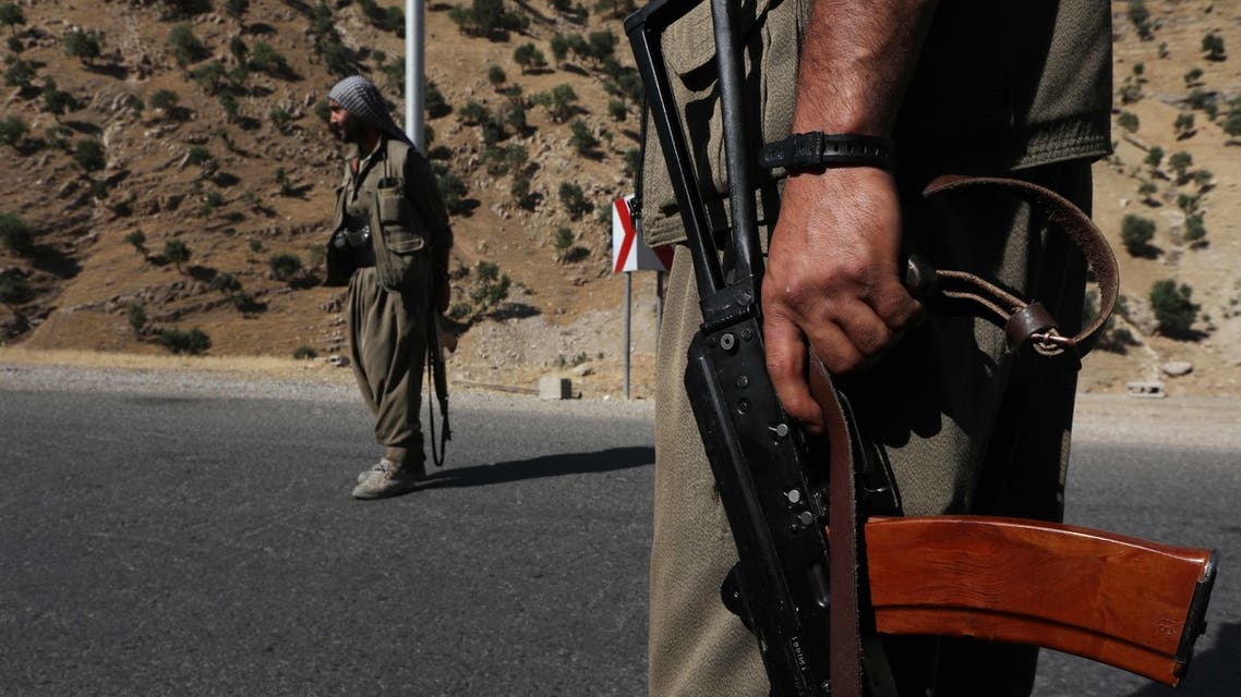 عضو في حزب العمال الكردستاني يحمل بندقية آلية على طريق في جبال قنديل، مقر حزب العمال الكردستاني في شمال العراق، في 22 يونيو 2018.