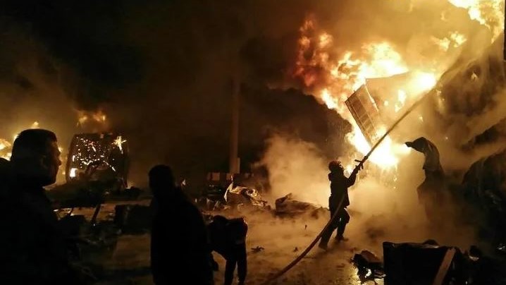 رجل إطفاء يكافح حريقًا في ميناء اللاذقية السوري بعد تعرضه لغارة جوية إسرائيلية