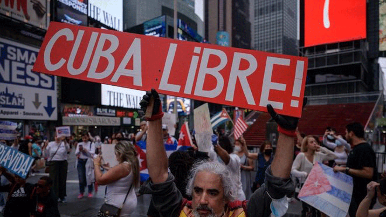 متظاهرون يحملون لافتات خلال مسيرة تضامنية مع الاحتجاجات المناهضة للحكومة في كوبا