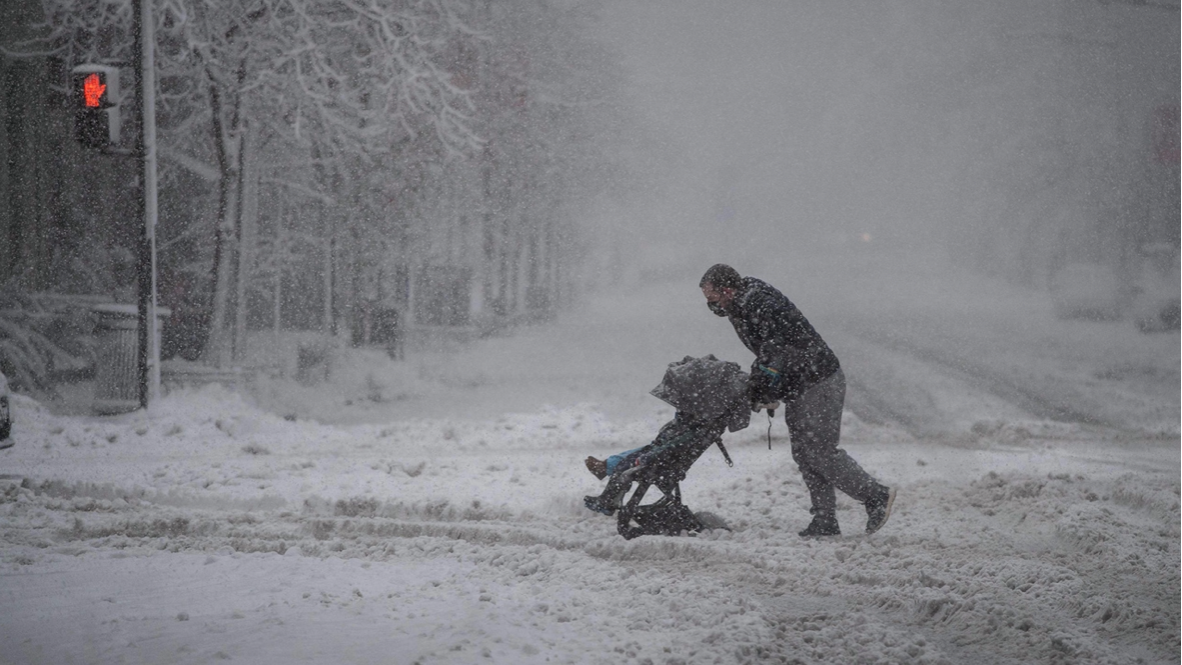 رجل يجر عربة فيها طفل في واشنطن في الثالث من كانون الثاني/يناير 2022