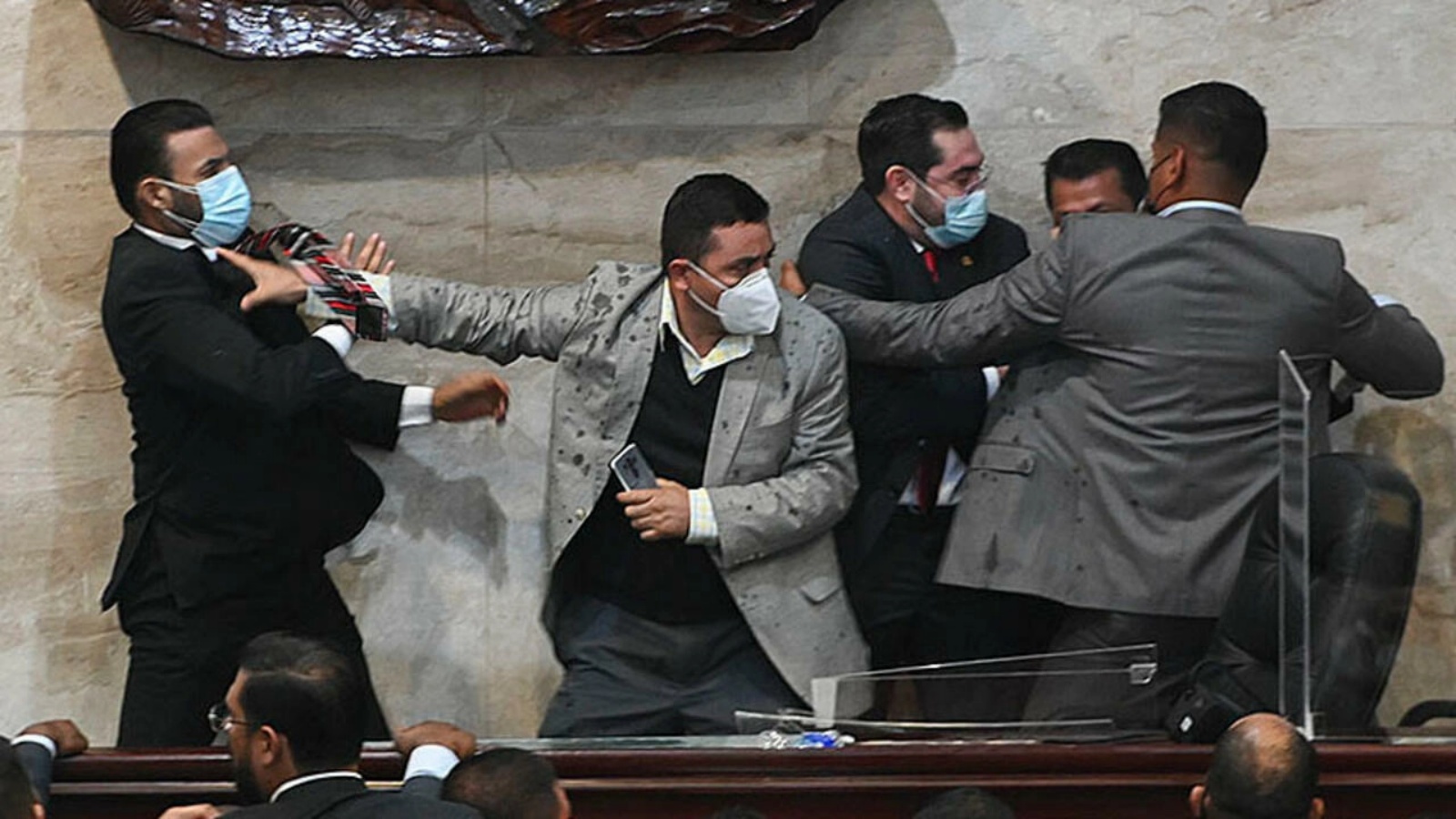 النائب راسل توميه (يسار) من حزب الحرية إعادة التأسيس يهاجم النائب خورخي كاليكس (الثاني من اليسار) بعد أدائه اليمين كرئيس للبرلمان في عاصمة هندوراس تيغوسيغالبا في 21 يناير 2022
