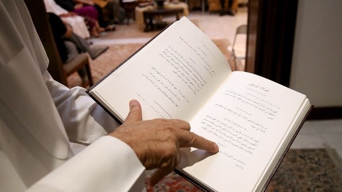 بهائي يقرأ في كتاب للصلاة الخاصة بالطائفة