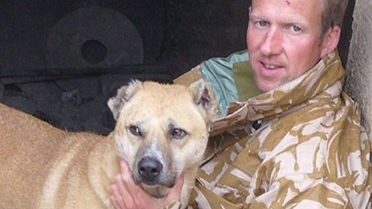 الجندي السابق فارتينغ مؤسس جمعية نوزاد محتضنا احد الكلاب