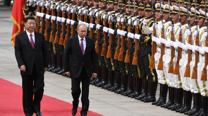 الرئيس الروسي فلاديمير بوتين يستعرض حرس الشرف العسكري مع الرئيس الصيني شي جين بينغ خلال حفل ترحيب خارج قاعة الشعب الكبرى في بكين في يونيو 2018