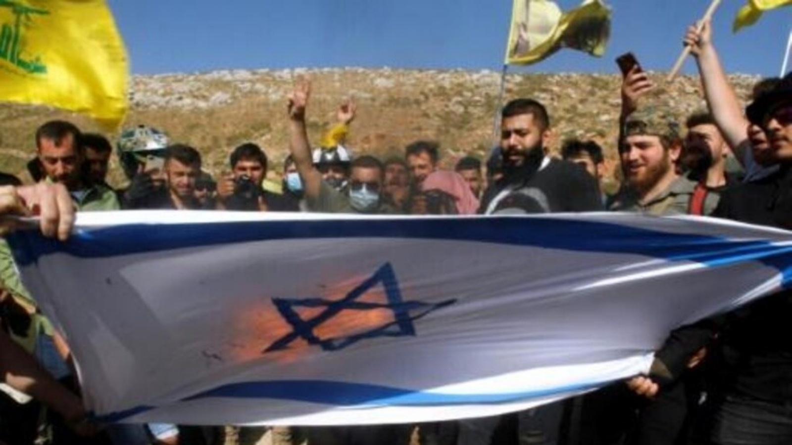 أنصار حزب الله يحرقون العلم الإسرائيلي في منطقة الخيام الحدودية في جنوب لبنان بتاريخ 25 مايو 2021 