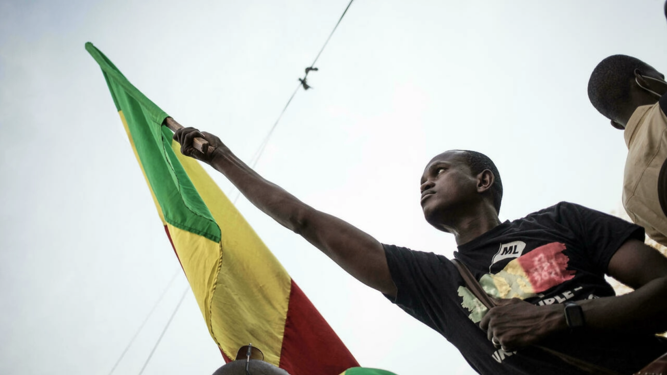 متظاهر يلوح بعلم مالي خلال مظاهرة في باماكو بتاريخ 10 كانون الثاني/يناير احتجاجا على عقوبات المجموعة الاقتصادية لدول غرب أفريقيا