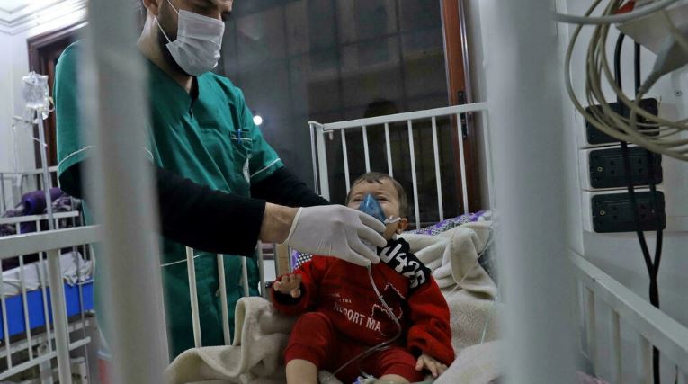 ممرض يثبت قناع الأوكسيجين على وجه طفل يتلقى الرعاية داخل أحد مستشفيات مدينة إدلب في شمال غرب سوريا في 1 فبراير 2022