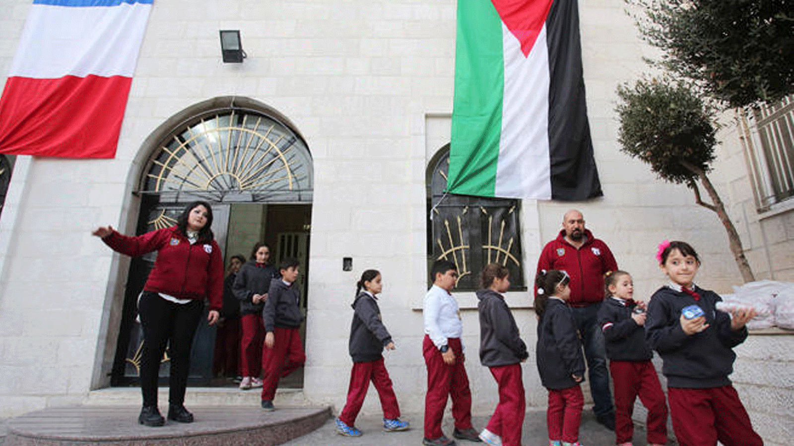 طلاب مسيحيون عراقيون يخرجون من مبنى مدرسة في عمان.